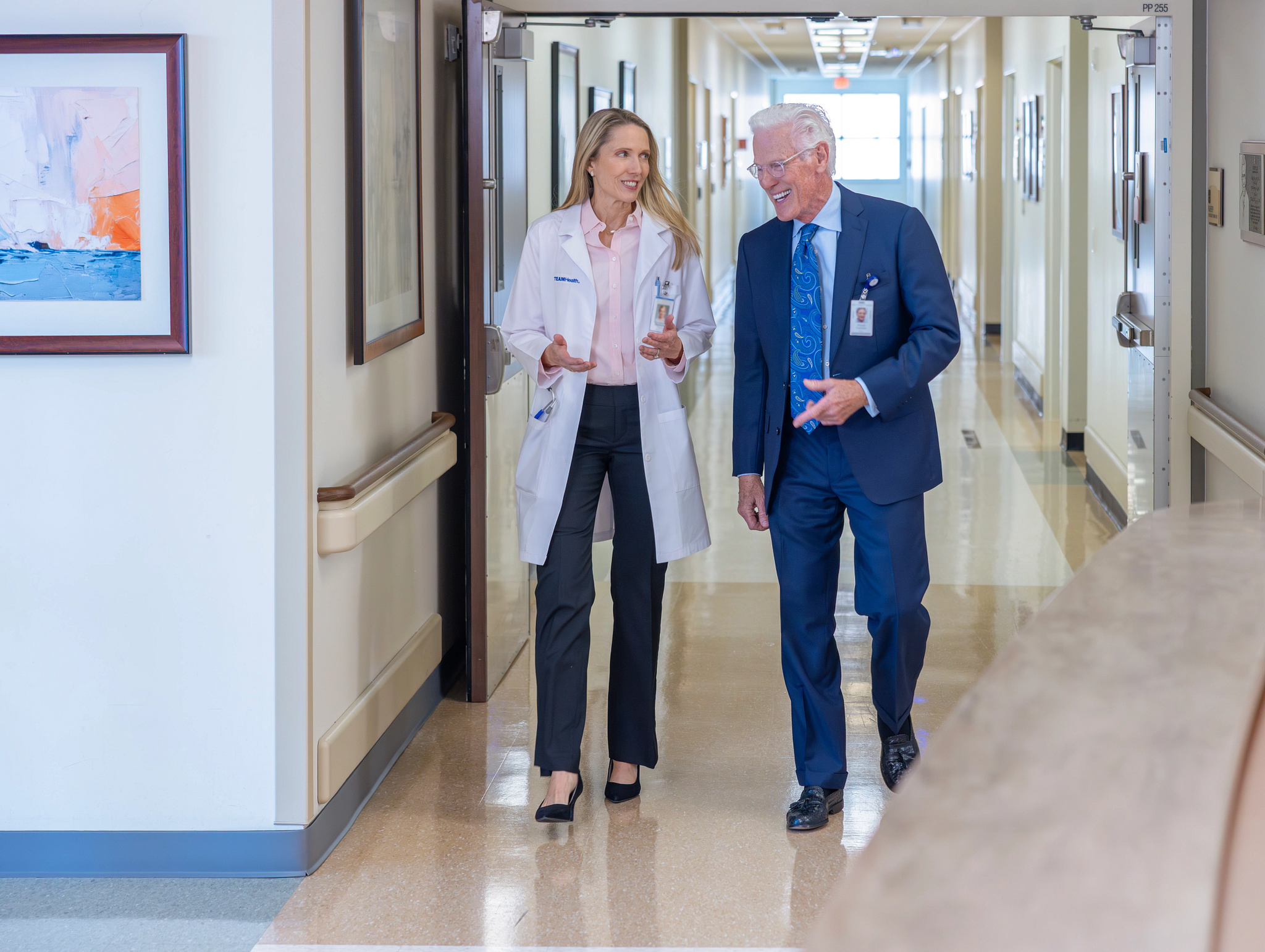 Physician and administration walking through hospital corridor
